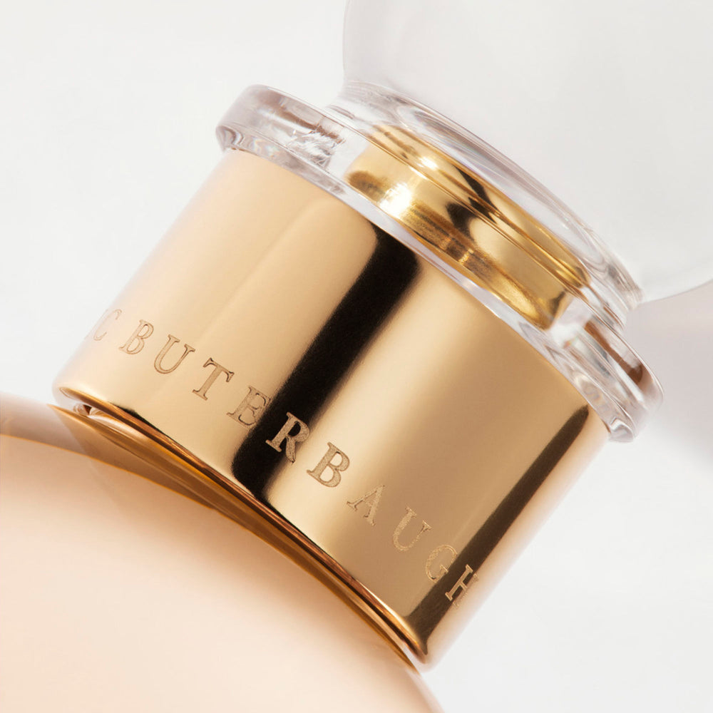 Detail of the top of the 100 ml bottle, with transparent glass and orangey perfum. Spherical cap with gold band. Regal Tuberose, a fragrance by Eric Butherbaugh.